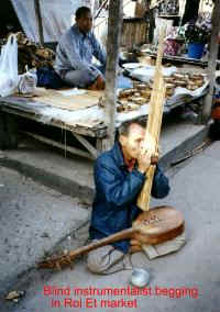 Beggar playing music in market